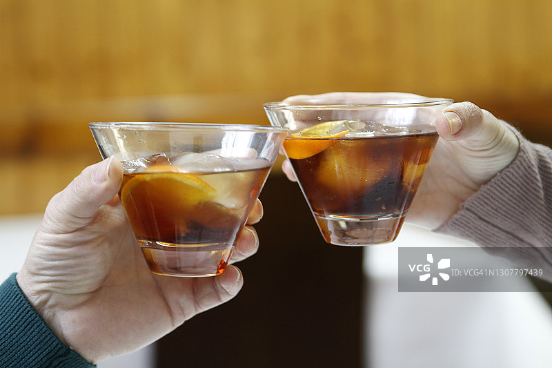 情侣举杯喝内格罗尼鸡尾酒庆祝图片素材