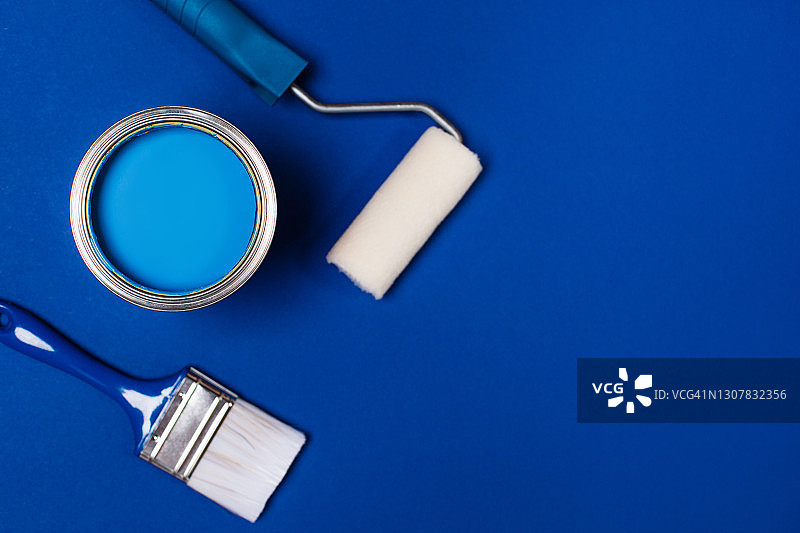 鲜蓝色颜料桶，滚筒和油漆刷，扁平风格，家居室内装修概念图片素材