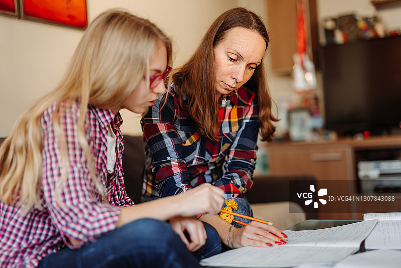疫情隔离期间母亲辅导女儿做作业图片素材