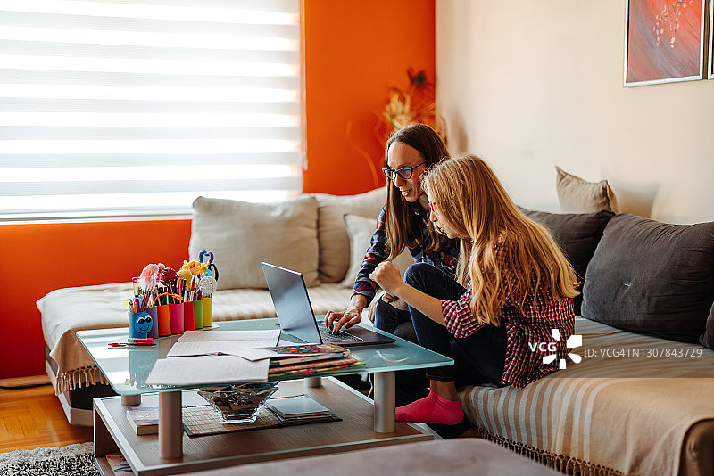 和母亲在家一起上网学习的快乐女孩图片素材