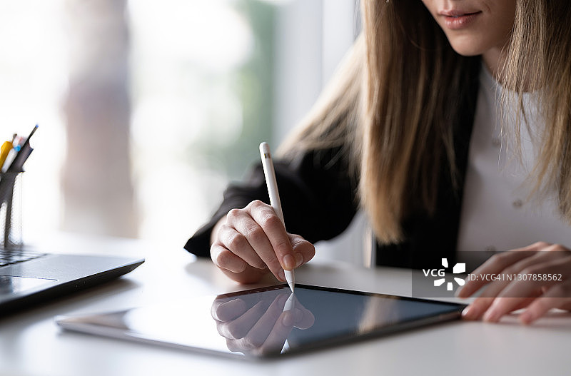 女商人在办公室用数位板签署法律文件图片素材