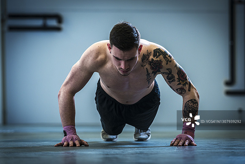 男人在健身房做俯卧撑图片素材