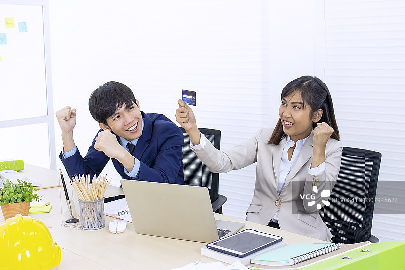 在线业务概念：情侣上班族因购买在线产品而收到礼物感到高兴图片素材