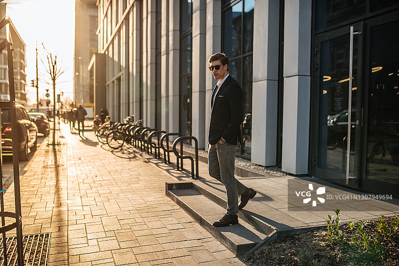 在金融区穿着商务装戴着太阳镜的年轻商人图片素材