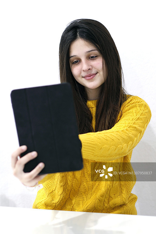 年轻女子在家中使用平板电脑图片素材