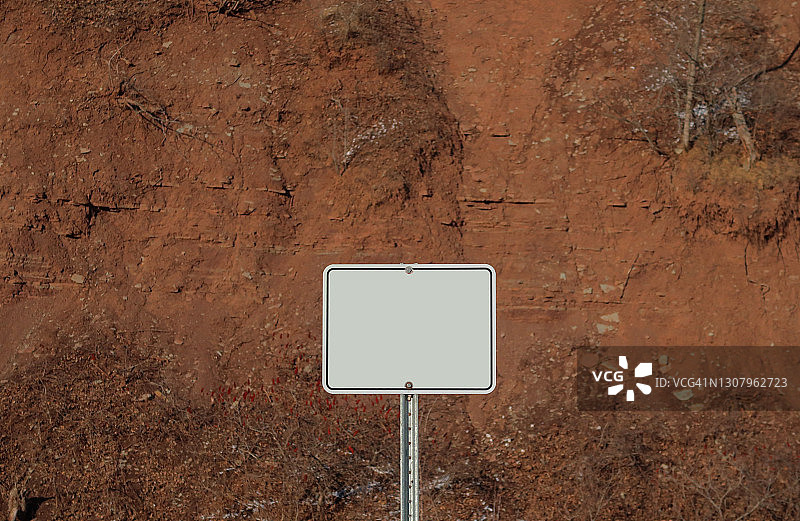 红色土壤悬崖背景上的白色空白标志图片素材