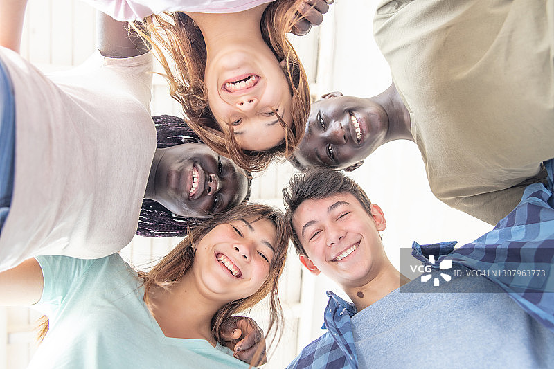 快乐的多种族朋友拥抱在一起，向下看的面部特写图片素材