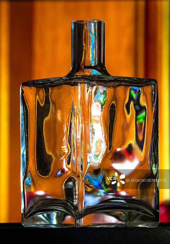 一个带有彩色反射的透明空玻璃瓶图片素材