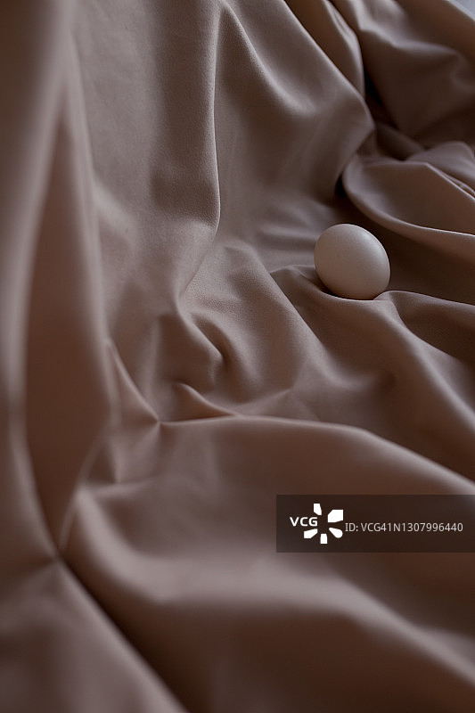 米色织物背景上的白色鸡蛋图片素材