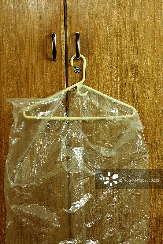 挂在衣柜把手上的透明防尘罩图片素材