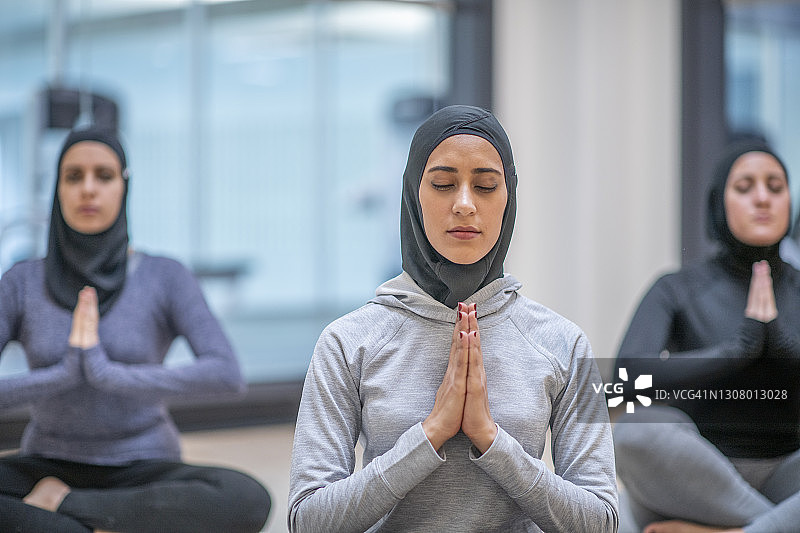 在瑜伽课上冥想的穆斯林妇女图片素材