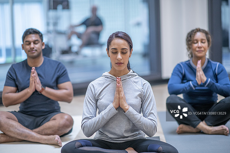 在瑜伽课上冥想的成年女性图片素材