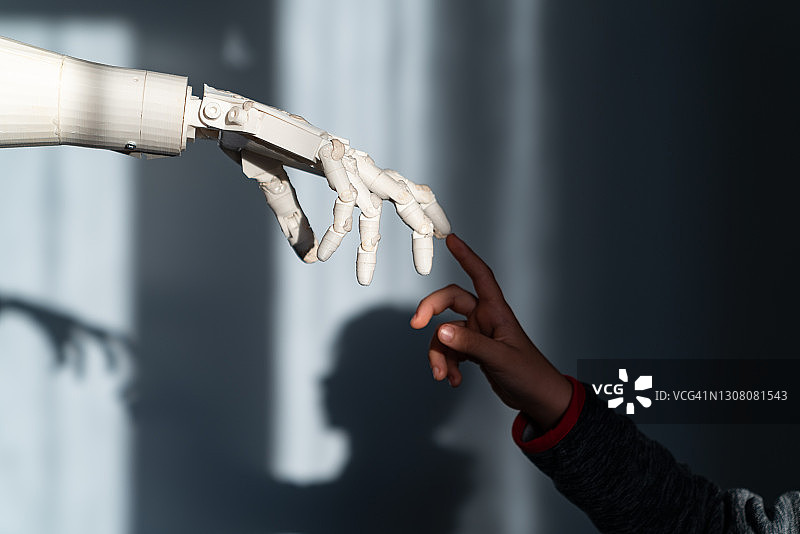 男孩触摸机器人的手指图片素材