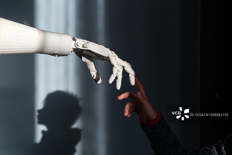 男孩触摸机器人的手指图片素材