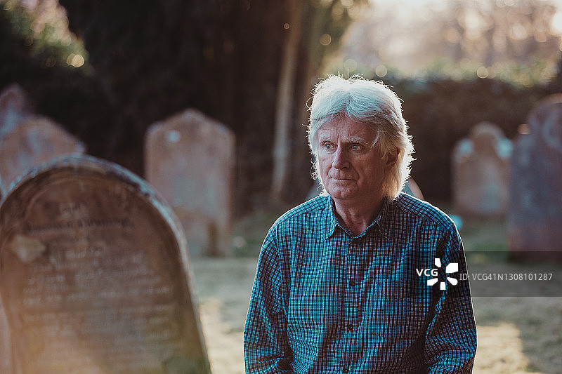 在墓地祈祷的悲伤男子图片素材