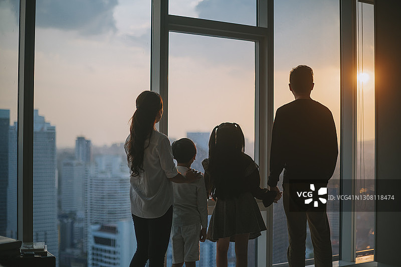 吉隆坡：欣赏日落的亚洲家庭背影剪影图片素材