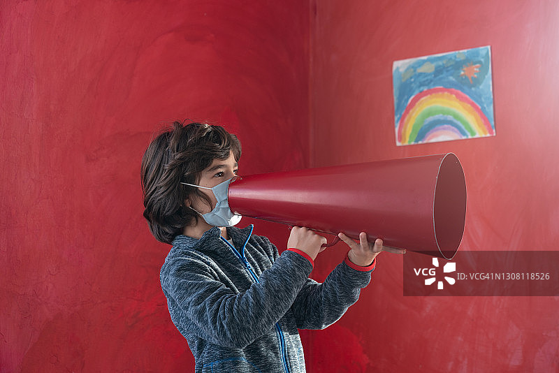 戴防护口罩的男学生使用扩音器讲话图片素材