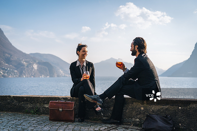 商务情侣在湖边一起喝饮品图片素材