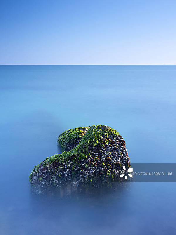 中国台湾新北市石门区老梅绿石槽。在东北季风的影响下，海浪拍打着礁石表面，海莴苣和“绿发”等绿色藻类缓慢生长，形成了老梅绿石槽的季节性景观图片素材