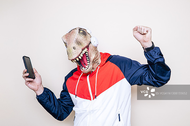 戴着耳机跳舞的快乐蜥蜴头男人图片素材