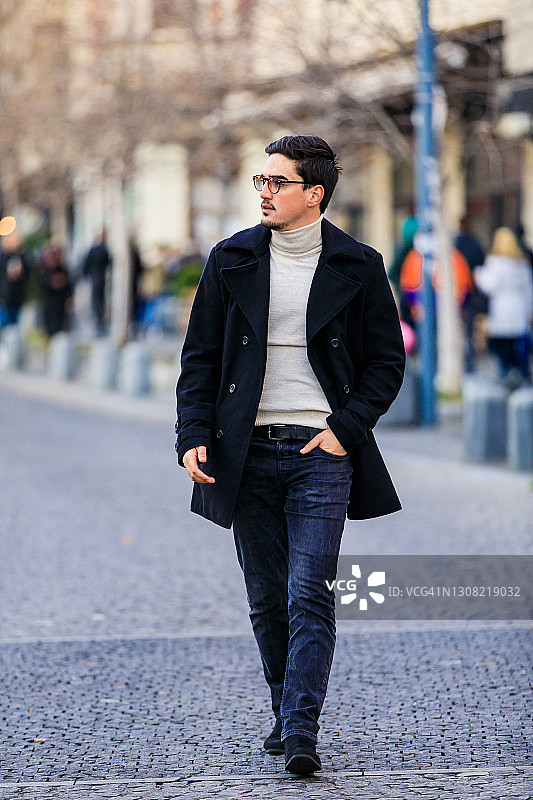 身穿黑色外套走在路上的时尚男士图片素材