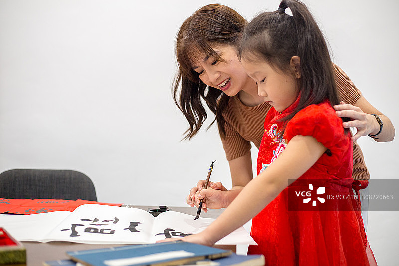 中国母亲教女儿练习中国书法图片素材