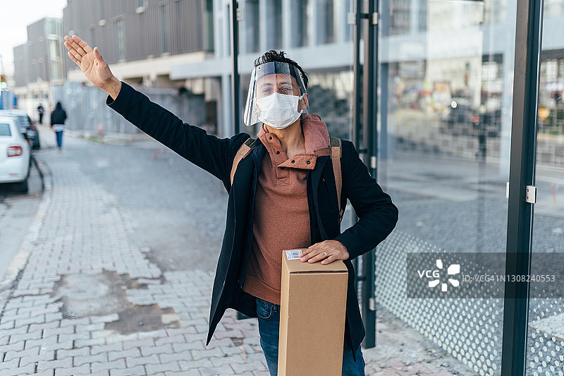 男人在街上戴着面罩等公共汽车图片素材