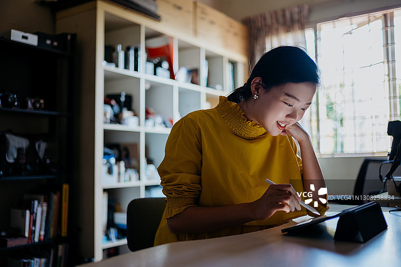 在家用平板电脑工作的年轻亚洲女性图片素材