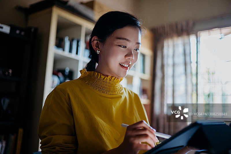 在家用平板电脑工作的年轻亚洲女性图片素材