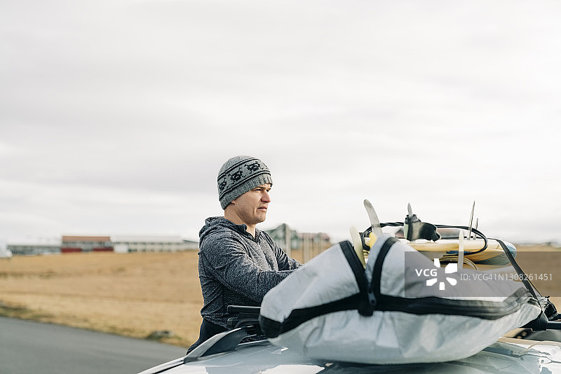 冲浪者将冲浪板装在车顶行李架上图片素材