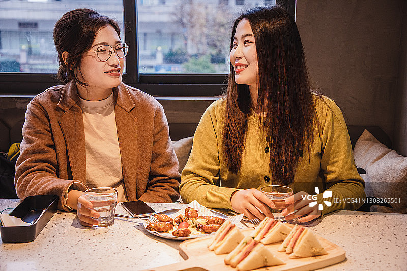 两位亚洲女性共进商务午餐，笑容满面图片素材