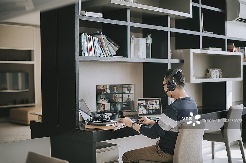 在家用耳机进行视频通话的中国籍中年男子图片素材