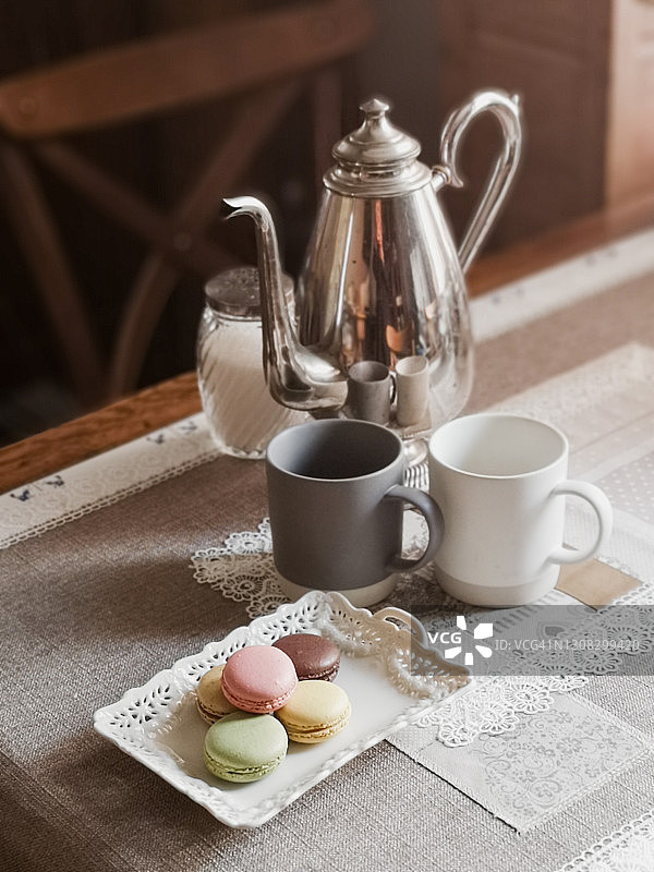 桌子上的咖啡杯、茶壶和饼干素材照片图片素材