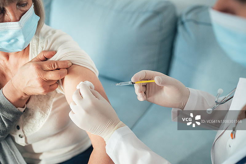 医生为老年妇女接种新冠疫苗图片素材