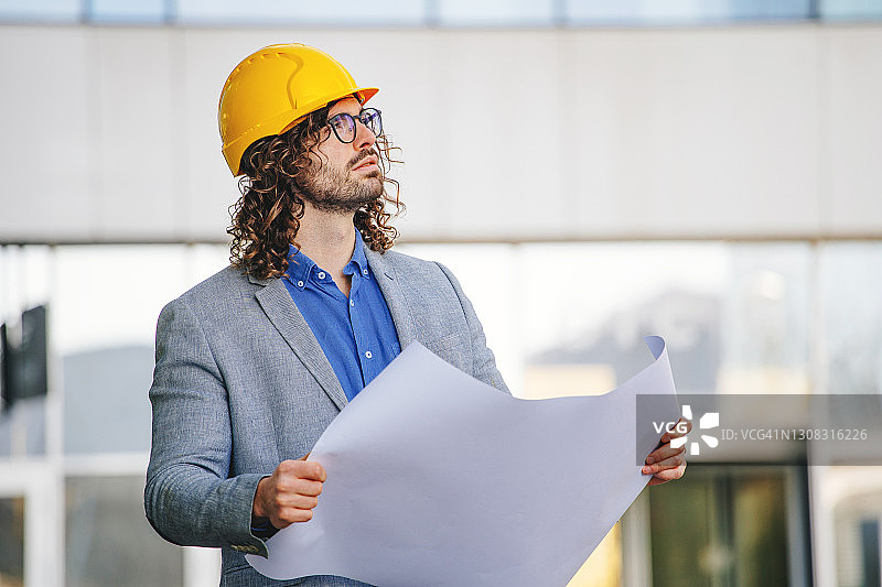 在建筑物前戴防护头盔的建筑师图片素材