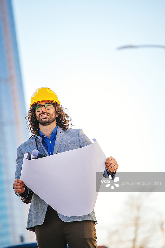 在建筑物前戴防护头盔的建筑师图片素材