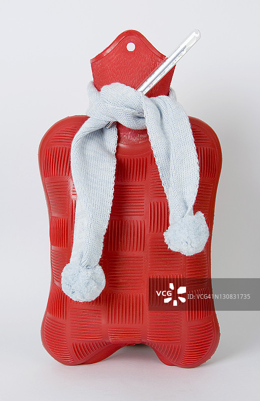 围巾包裹着热水瓶和温度计，流感象征图片素材