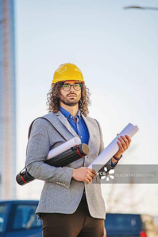 在建筑物前戴防护头盔的建筑师图片素材