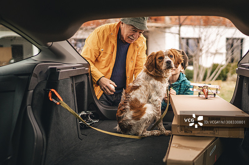 祖孙和坐在汽车后备箱里的狗图片素材