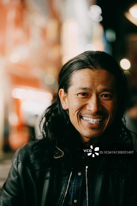 东京夜景：另类风格的日本男子对着镜头微笑图片素材