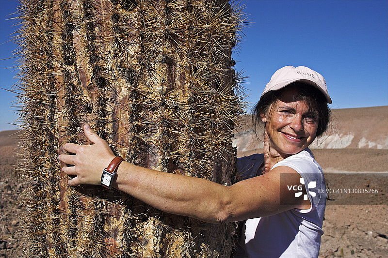 在智利阿塔卡马沙漠手持仙人掌的女人图片素材