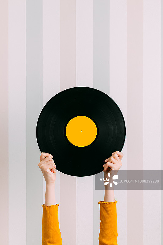 手持黑胶唱片的年轻白人女孩正面图图片素材
