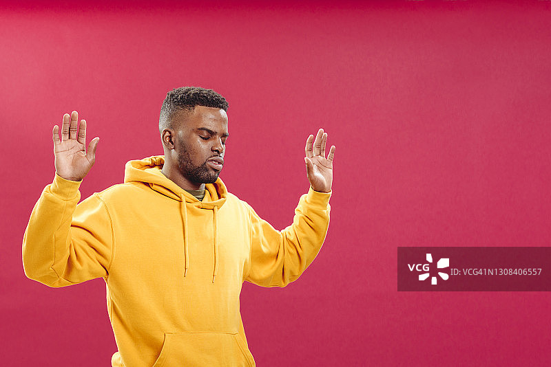 绝望的黑人男子穿着连帽衫，举起双手图片素材