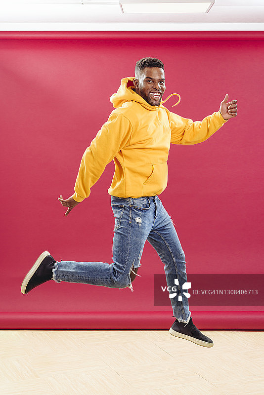 快乐的黑人潮人在工作室跳跃图片素材