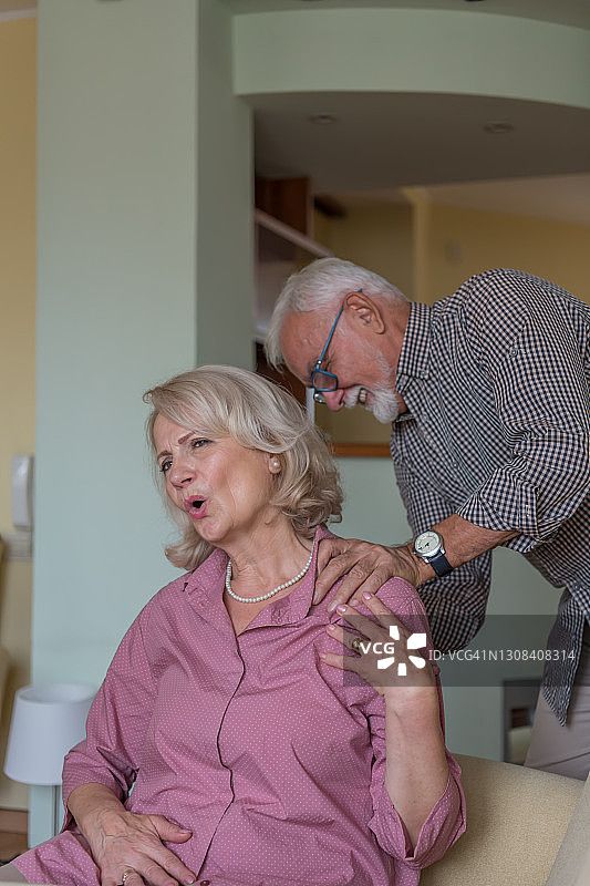 老妇人为有细心的丈夫在身边而感到高兴，年长的男人正在为妻子按摩图片素材