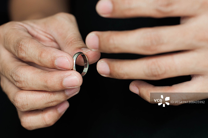 一名戴着结婚戒指的东南亚男子，黑色背景图片素材