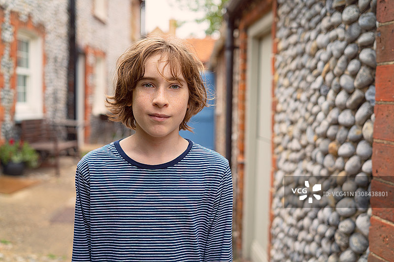 在诺福克郡小屋前的青少年男孩图片素材