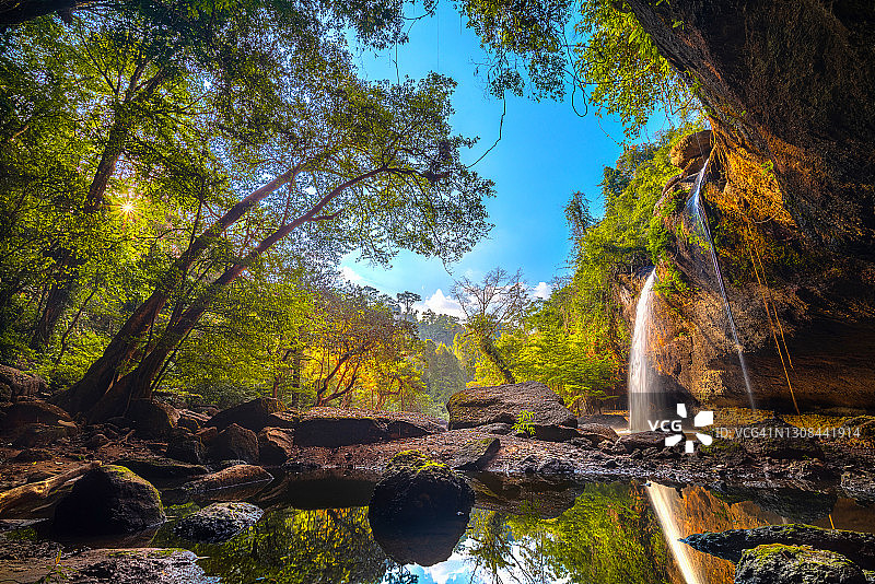 在泰国呵叻府考艾国家公园（联合国教科文组织）的Haew Suwat瀑布，日落前美丽的景色，洞穴和天然树木构成框架，在狂野的水和岩石上反射出倒影，令人惊叹的未见瀑布图片素材