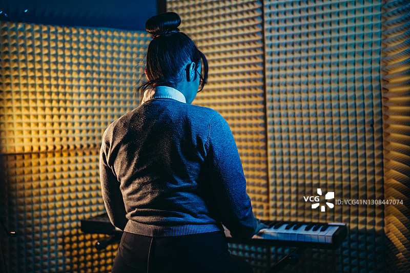 在工作室里弹电子钢琴的女人图片素材