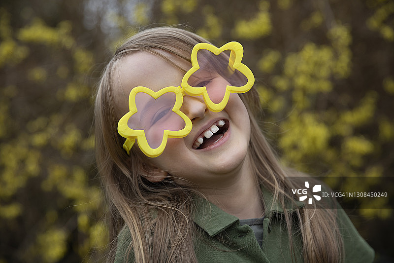 戴着黄色星星造型新潮太阳镜的微笑儿童图片素材